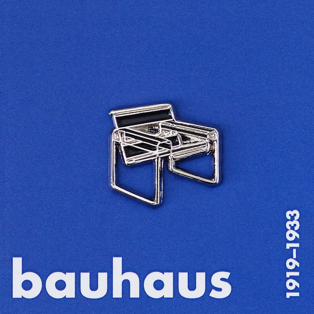 Metallic chair pin on a blue background with &#39;bauhaus&#39; text