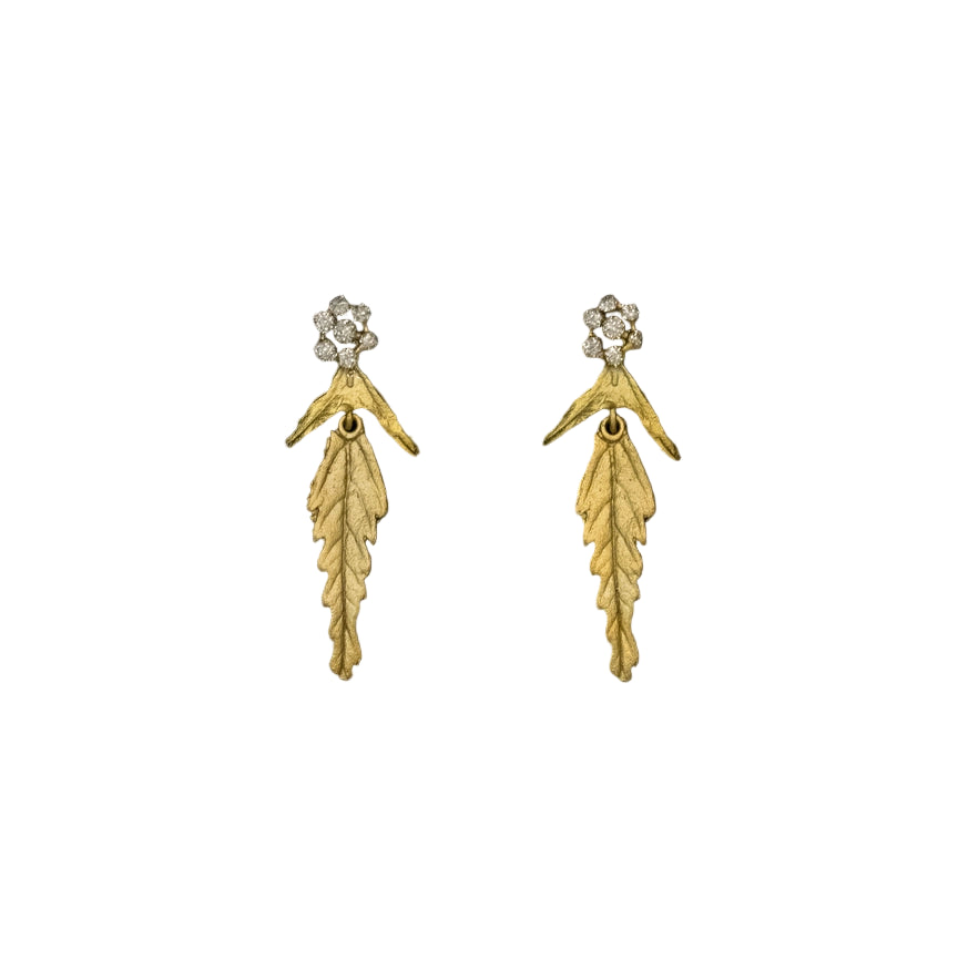 Gold leaf-shaped earrings with small crystals on a white background