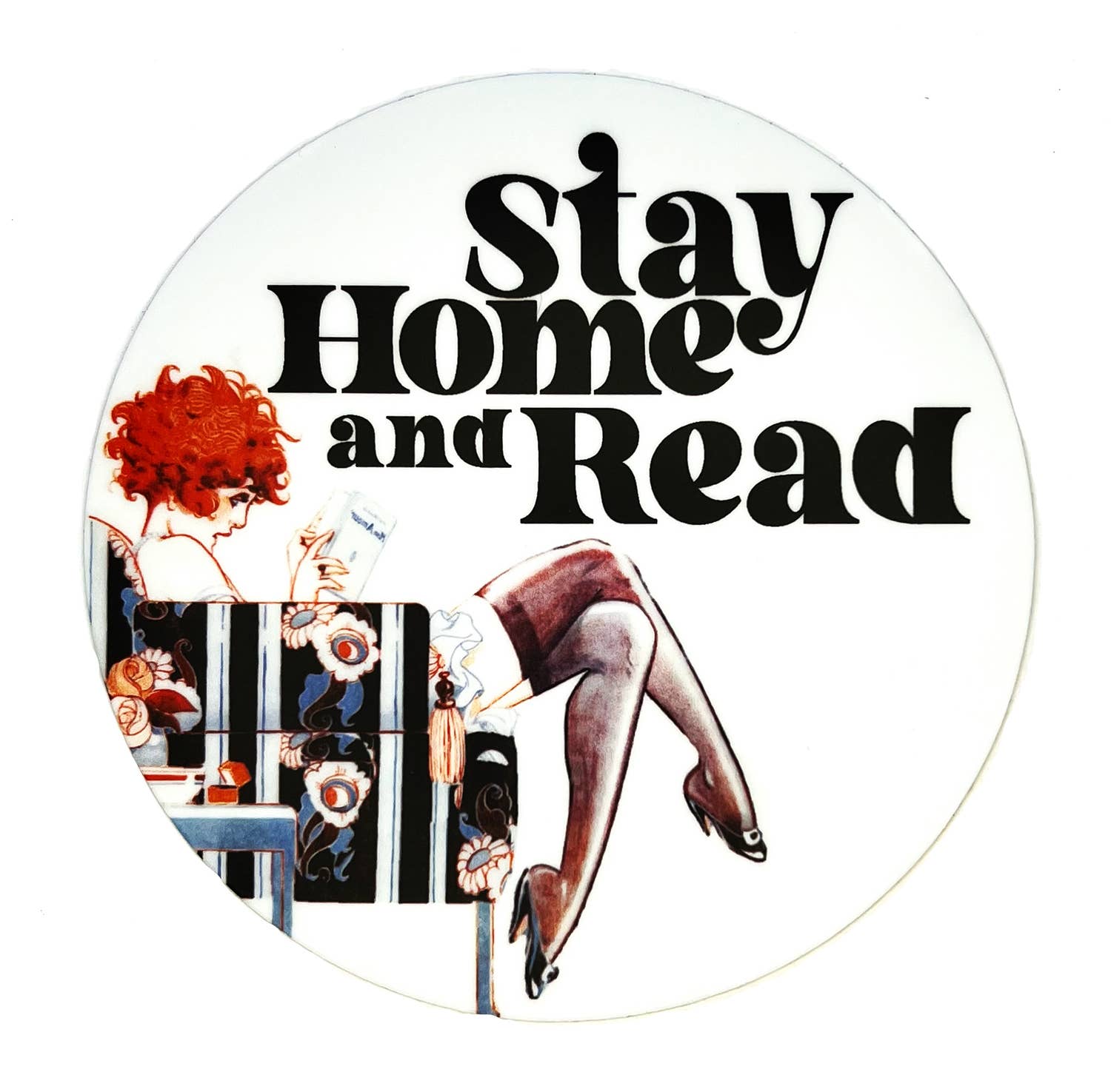 Circular graphic with text 'Stay Home and Read' and a stylized illustration of a red-haired women reading a book in a floral chair next to a side table. 