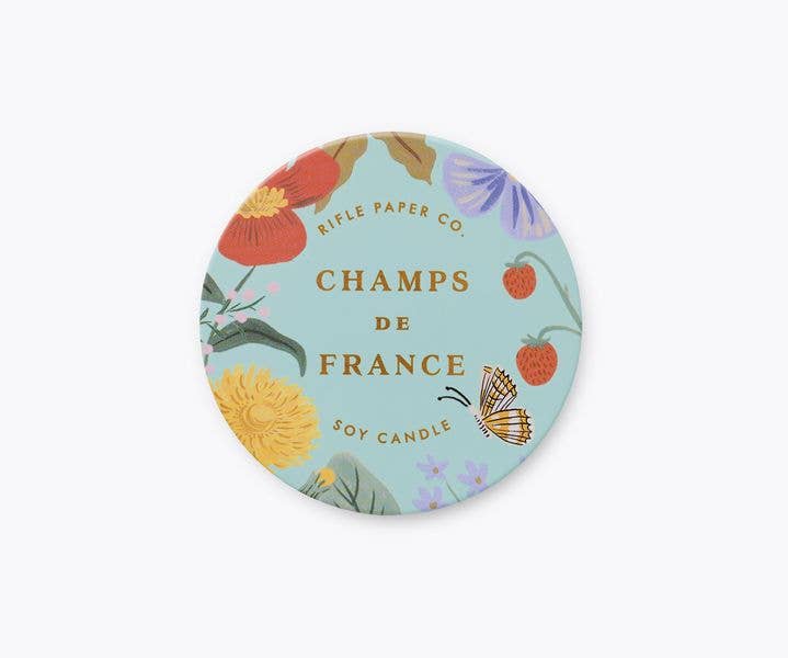 Floral candle packaging with &#39;Champs de France&#39; text on a light blue background