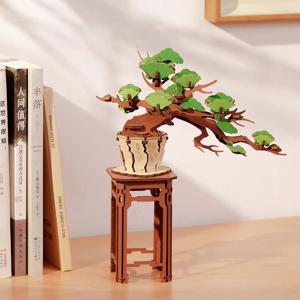 Wooden bonsai tree model on a stand with books in the background
