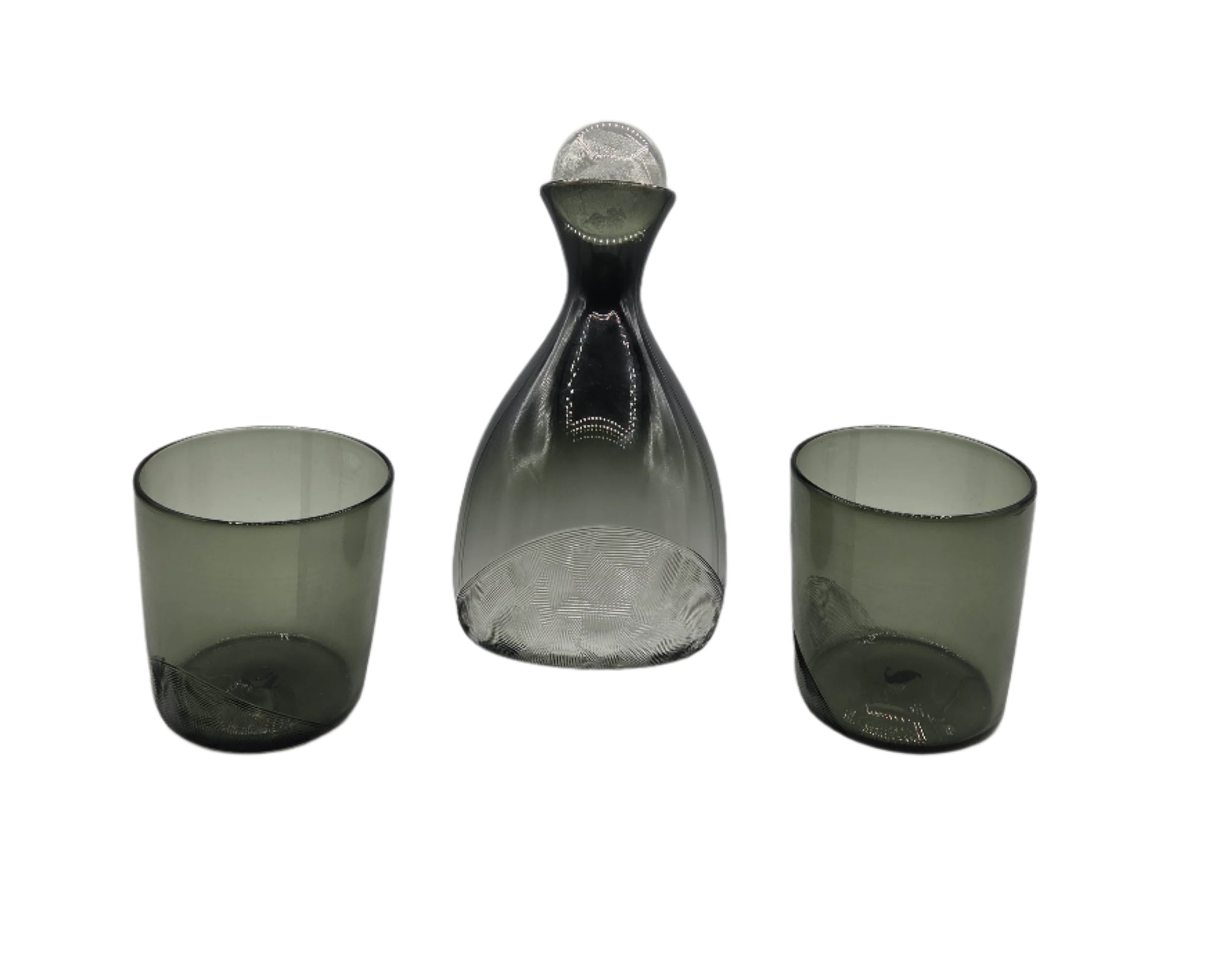 Set of three smoked glass pieces including a decanter and two tumblers on a white background