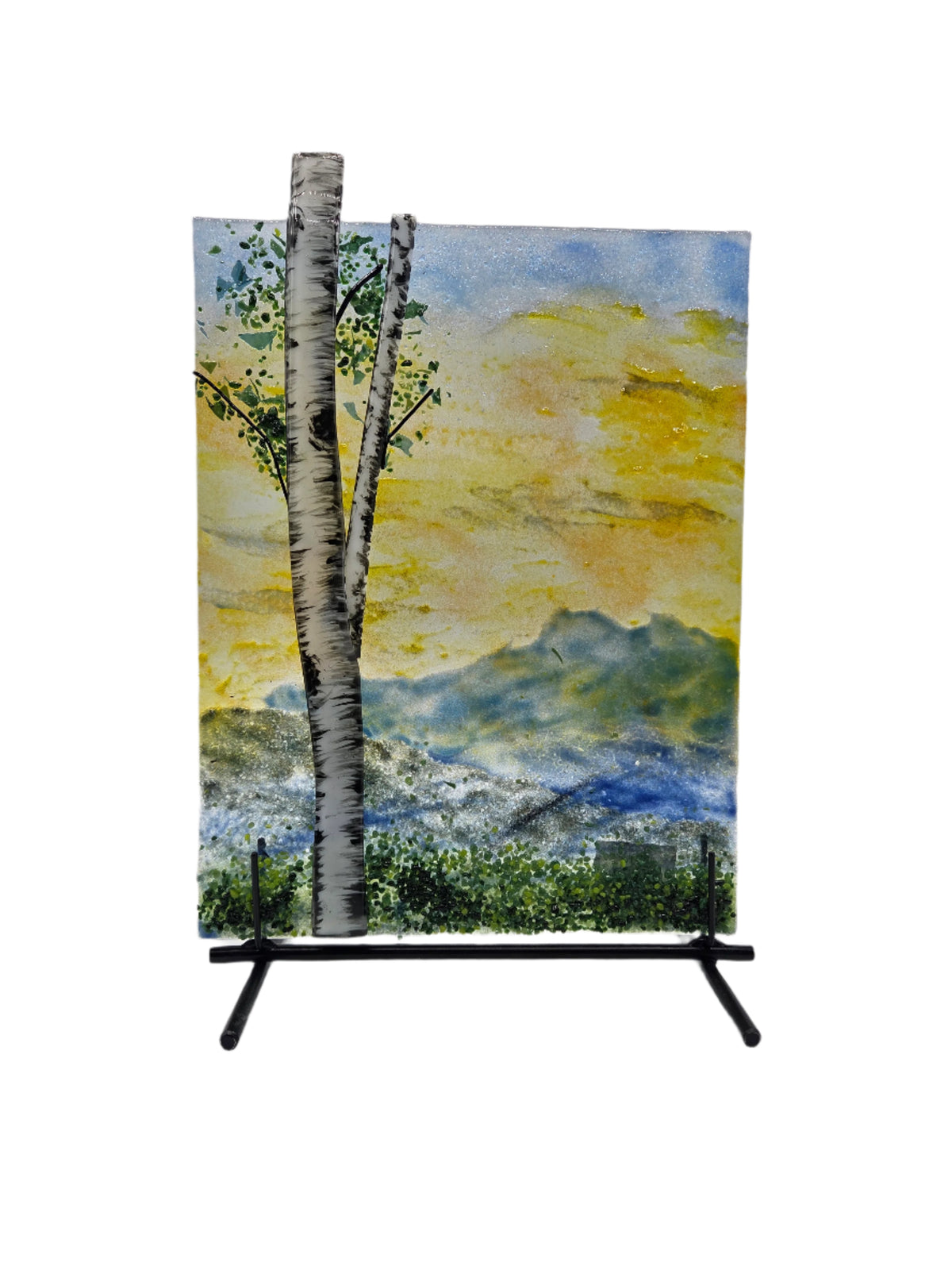 Glass panel of a tree with a mountain landscape on a metal stand