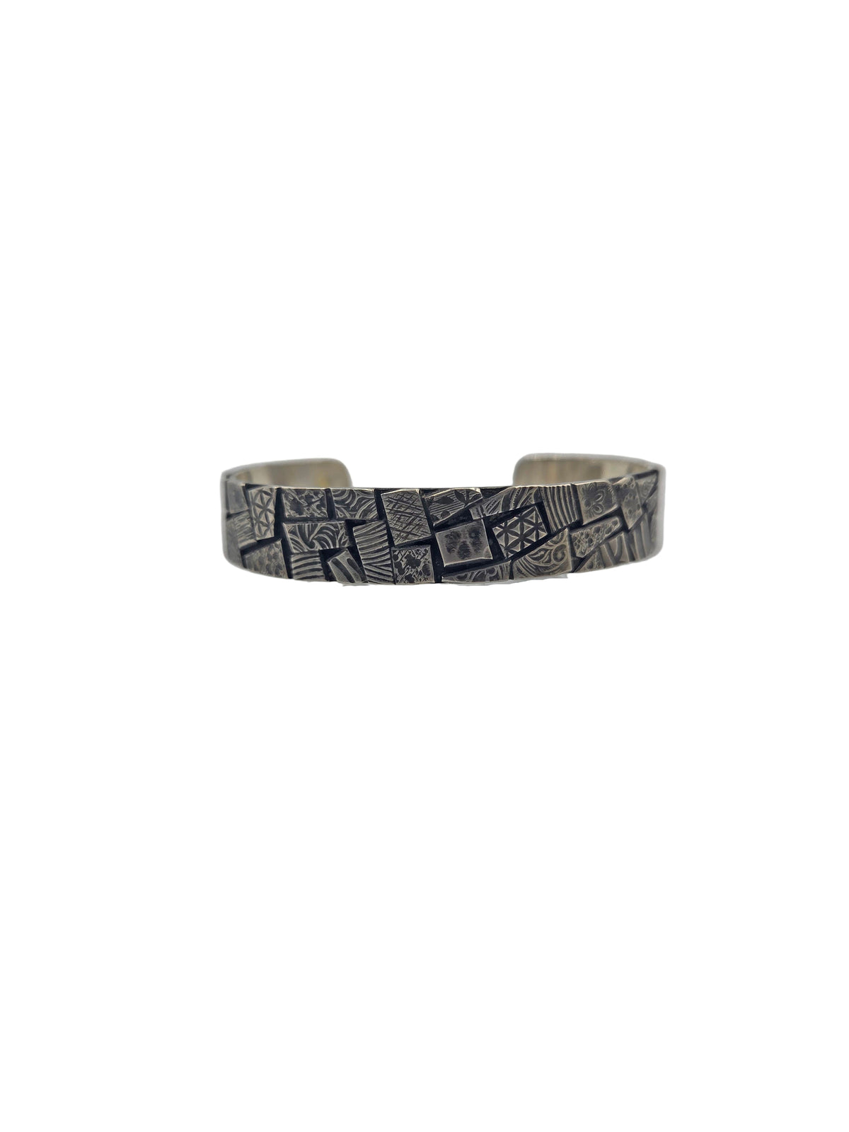 Silver bracelet with embossed design on a gray background