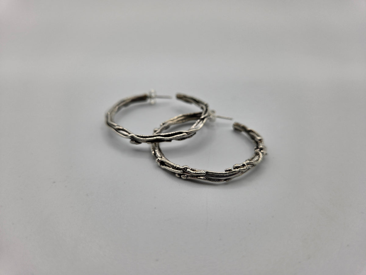 Pair of silver hoop earrings on a white background