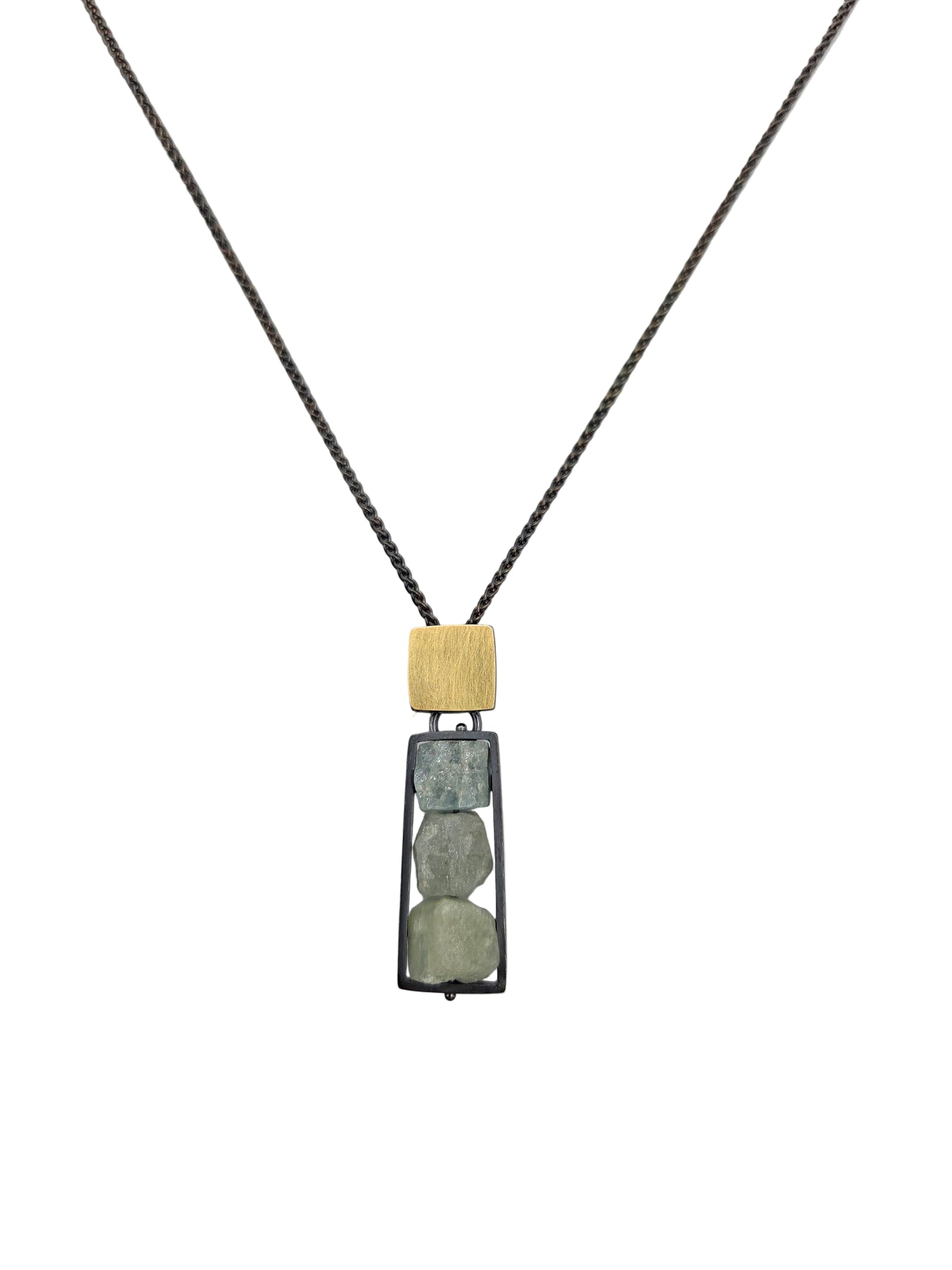 Necklace with a rectangular pendant featuring a gold top and rough unpolished blue gemstones