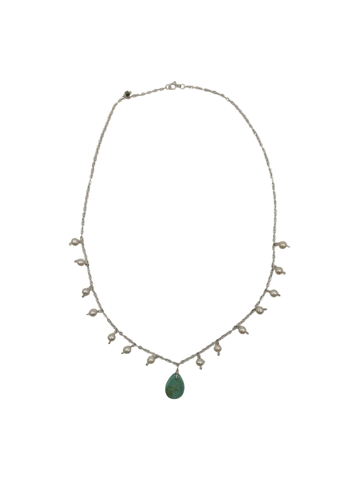 Delicate necklace with pearls and a green stone on a white background