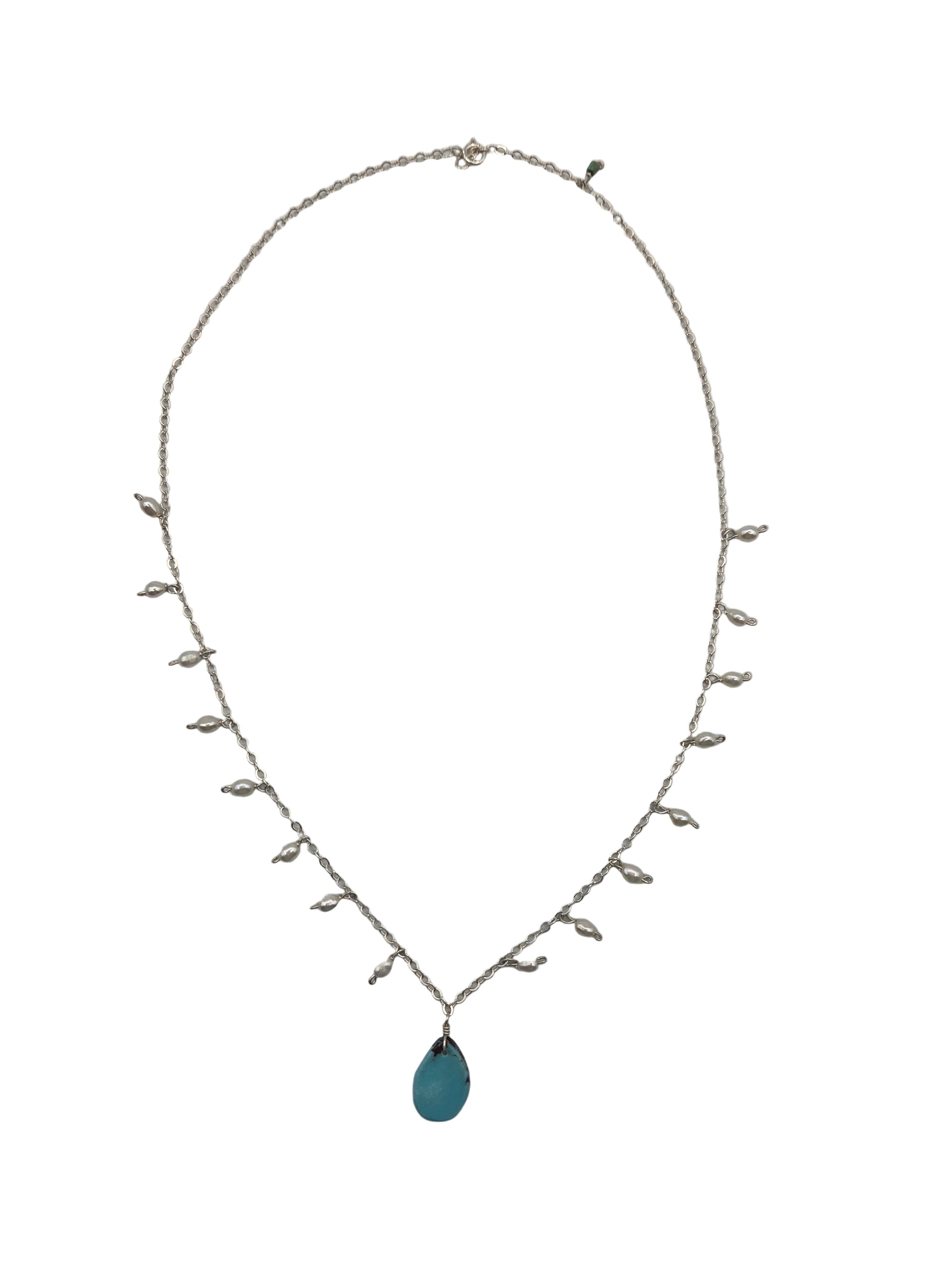 Delicate necklace with pearls and a blue stone on a white background