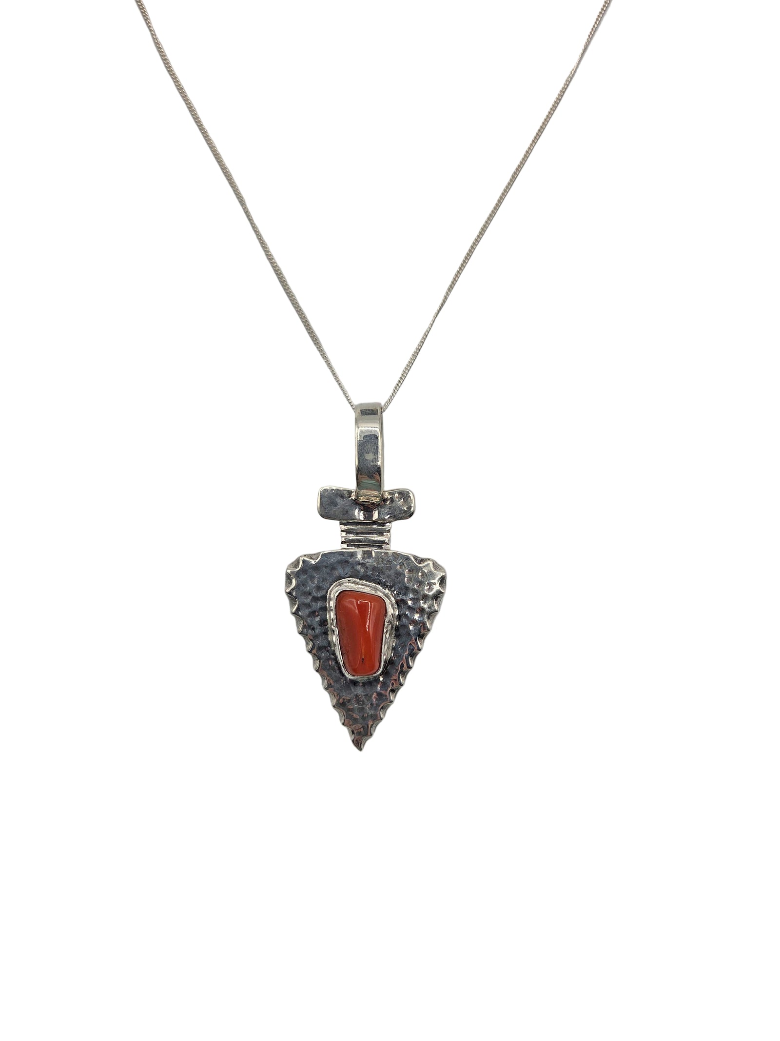 Silver pendant with a red stone on a white background