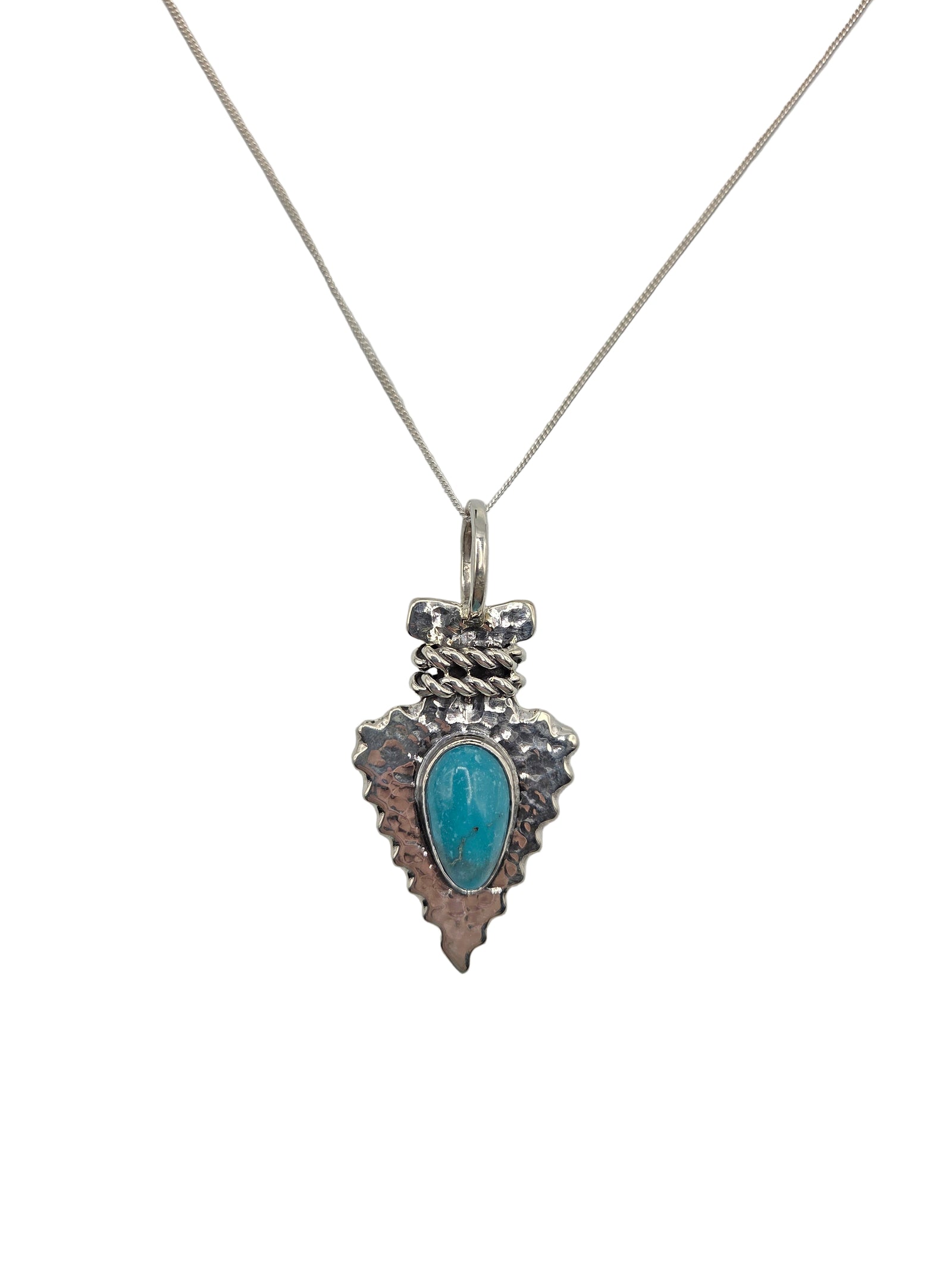 Silver arrowhead pendant with turquoise stone on a white background