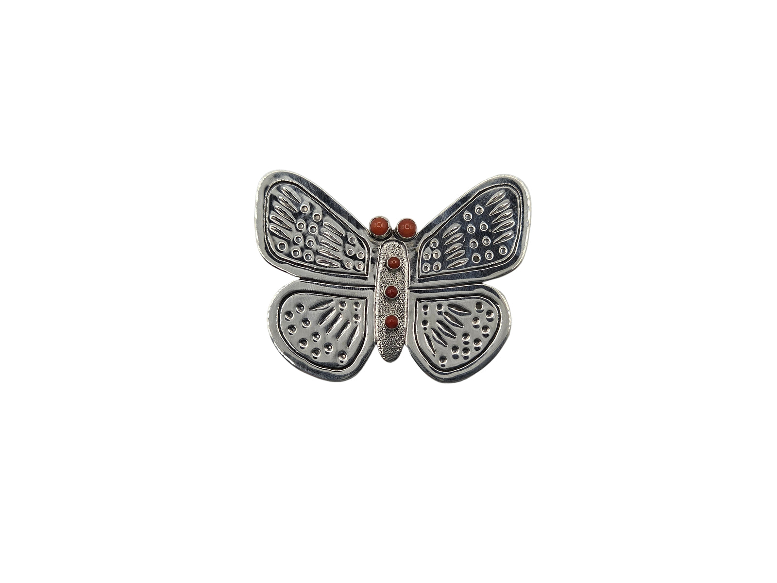 Silver butterfly-shaped brooch with red stones on a white background