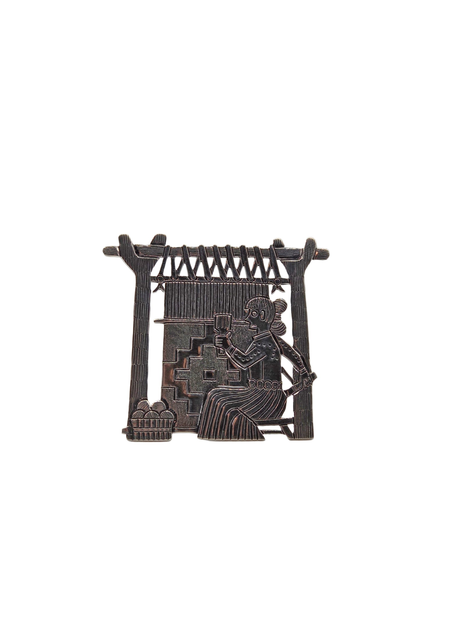 Decorative metal brooch with a design of a person weaving on a loom on a white background