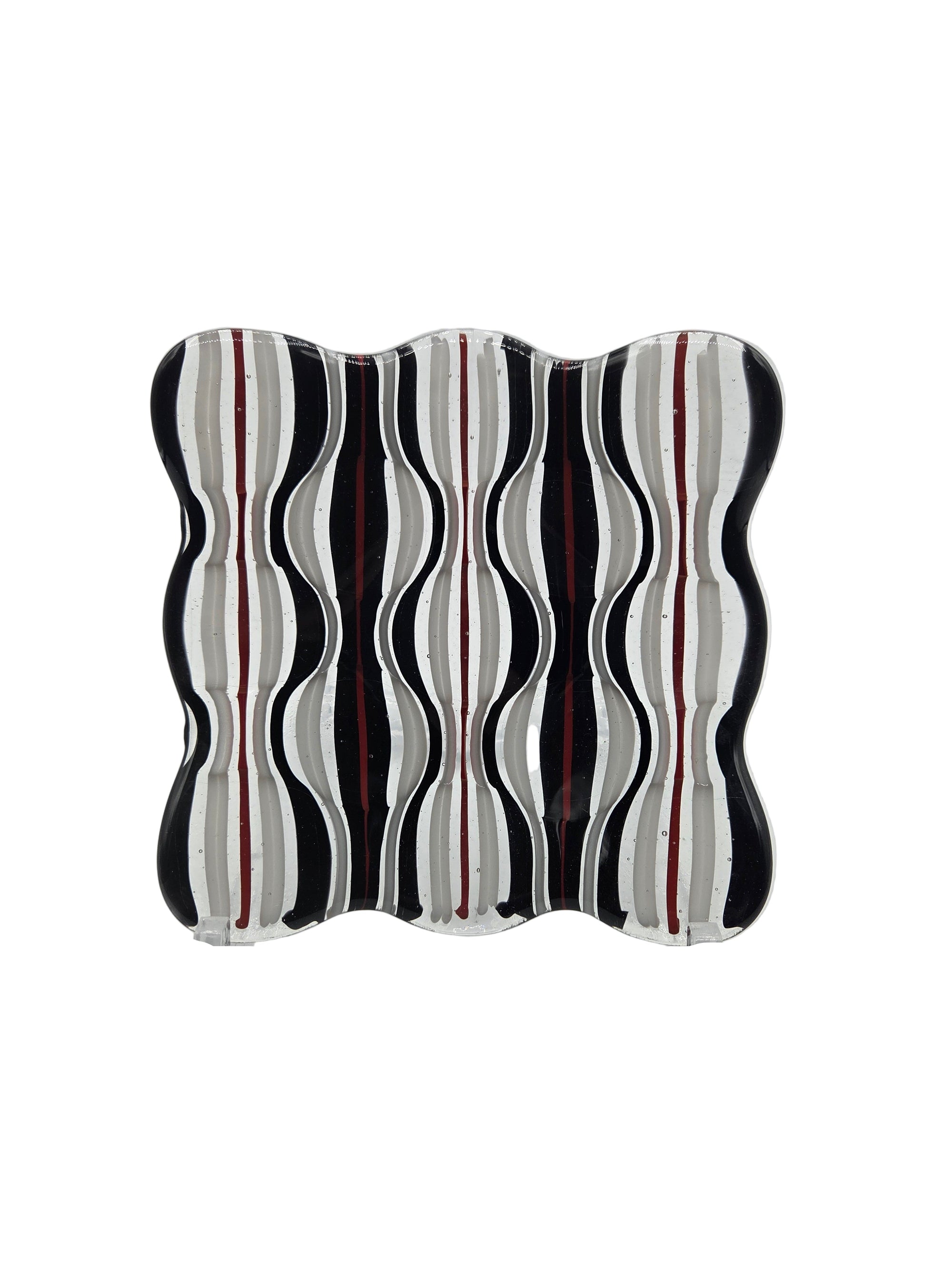 Decorative glass with wavy black and white design on a white background