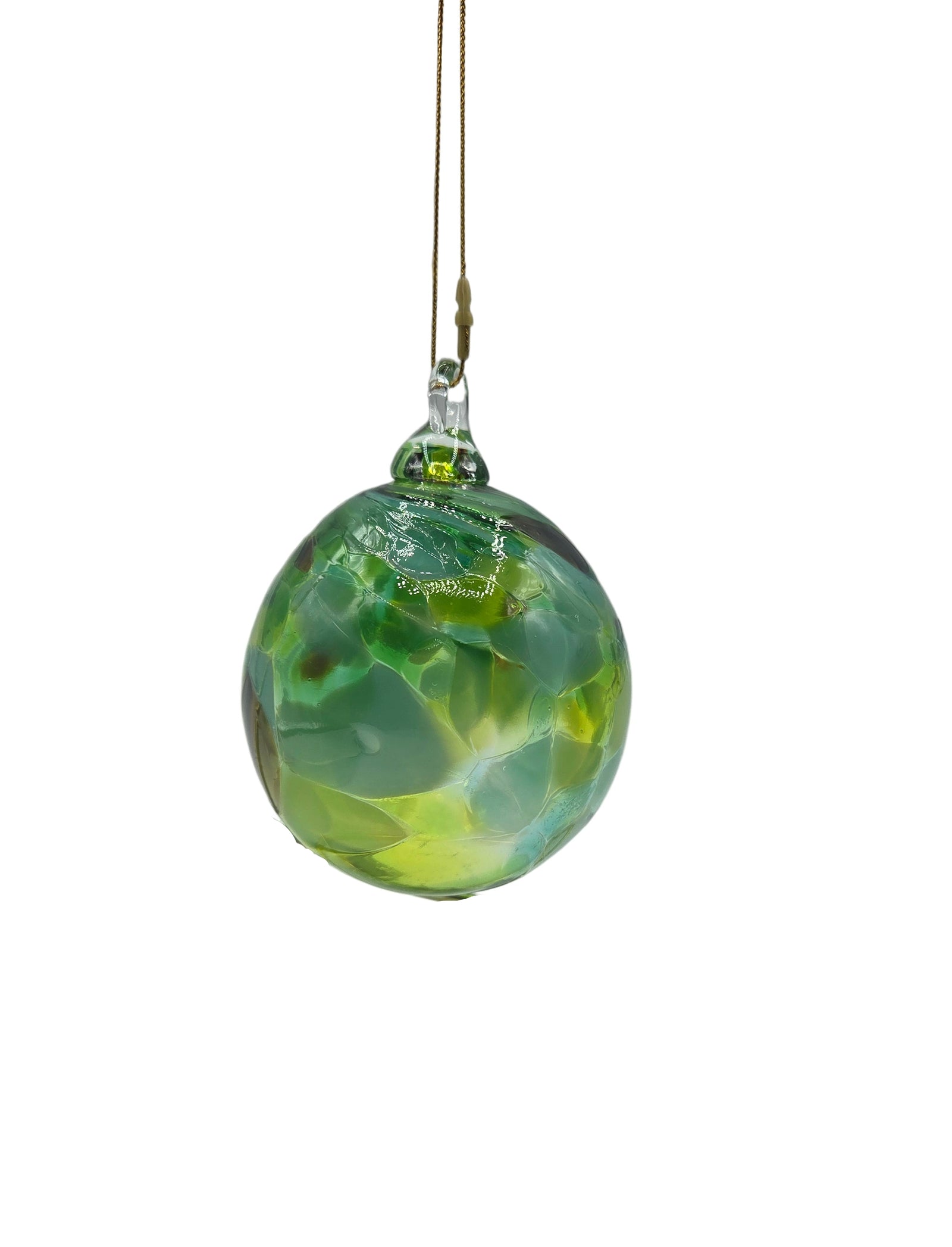 Green glass ornament hanging on a wire against a gray background
