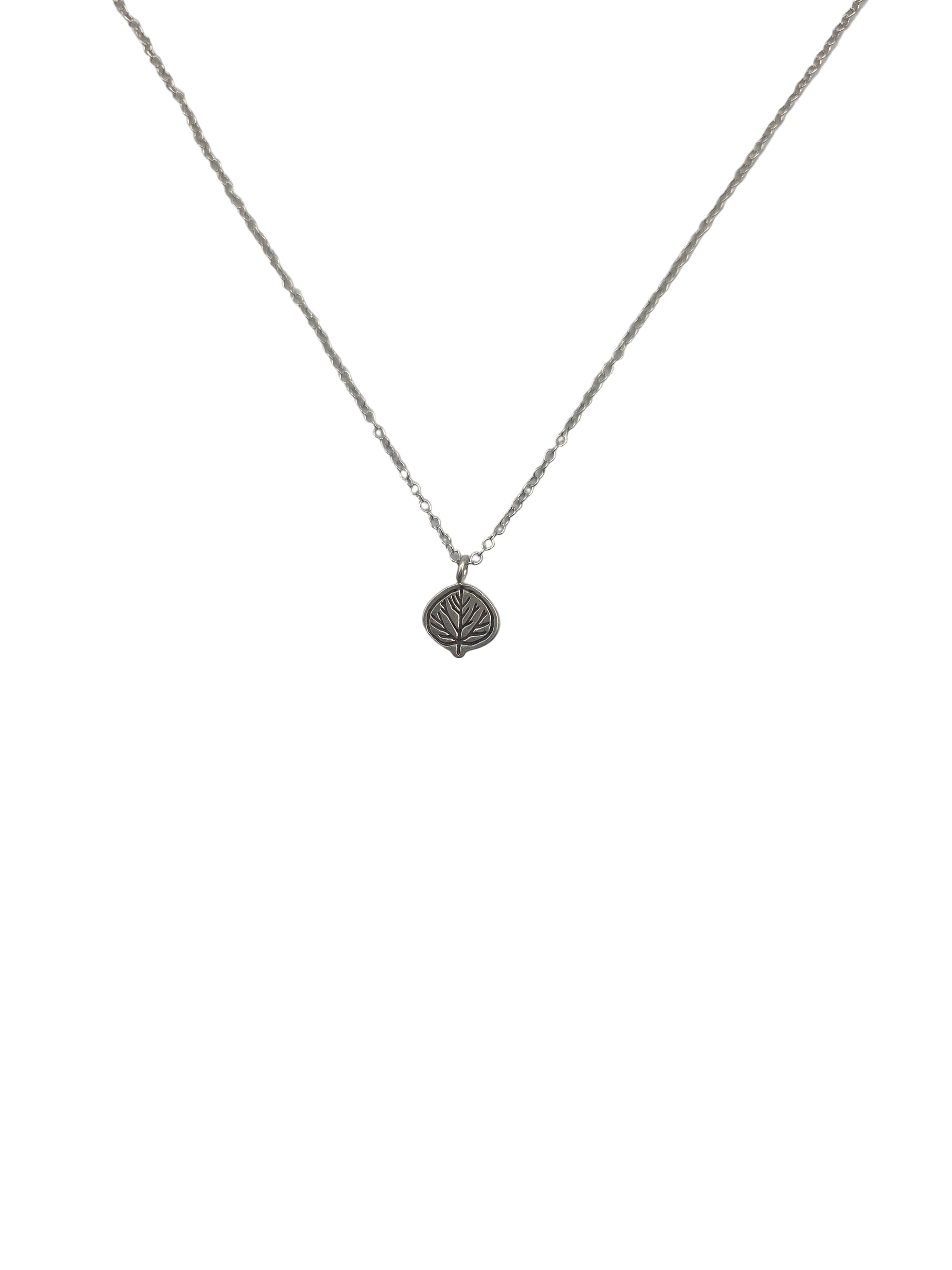 Silver necklace with a leaf pendant on a light gray background