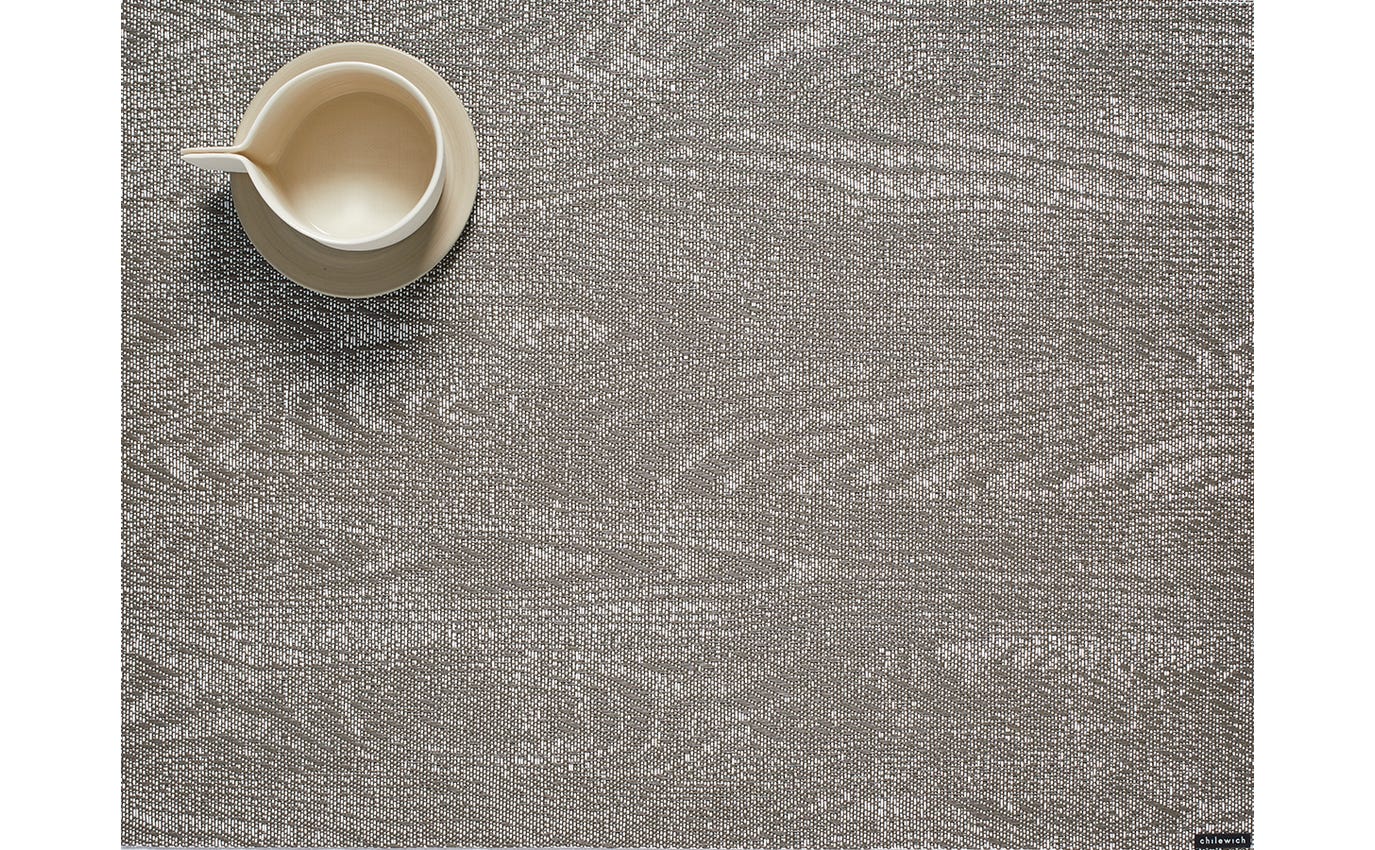 Textured gray placemat with a small white mug on a matching background