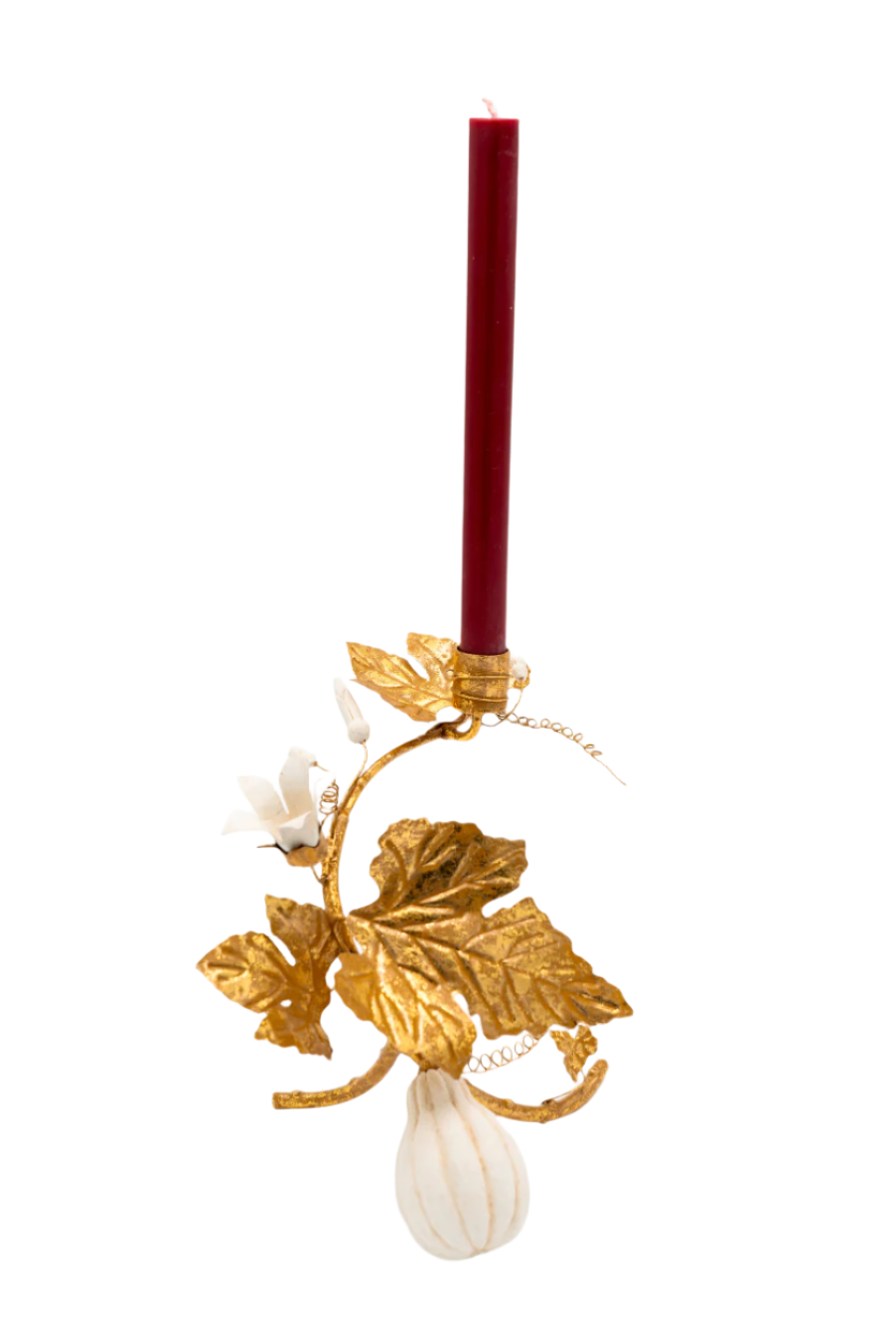 Decorative candle holder with gold leaves, white gourd, and a red candle on a white background