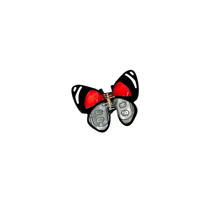 Butterfly-shaped hair clip with red center and black wings on a white background