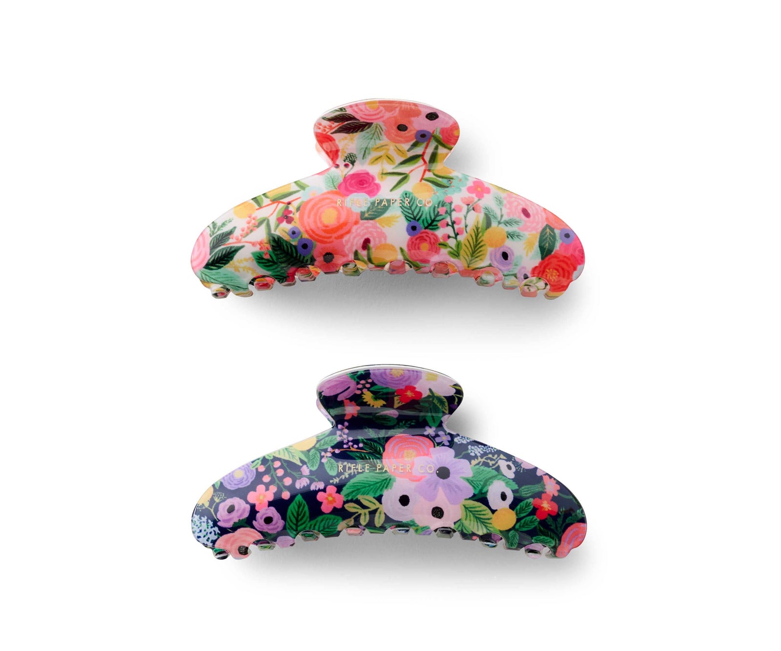 Two floral-patterned hair clips on a white background. One more pink flowers and one with a dark blue background with more blue flowers