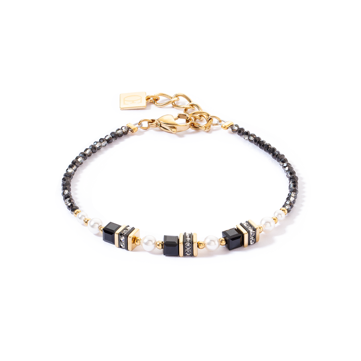 Bracelet with black, gold, and pearl beads on a white background