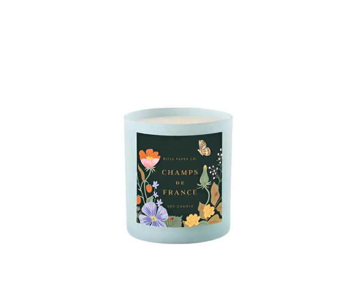 Candle with floral label that says Champs de France Soy Candle on a white background