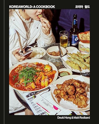 Cookbook cover with images of Korean food and people enjoying a meal, featuring the title 'Koreaworld: A Cookbook' by Deukli Hong & Matt Rodbard.