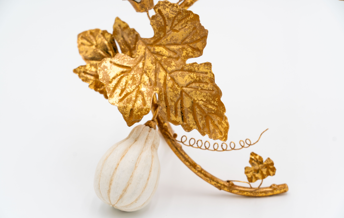 Gold leaf and gourd decorative item on a white background
