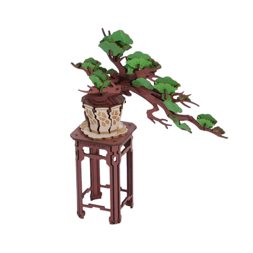 Model of a bonsai tree on a stand with green leaves against a white background