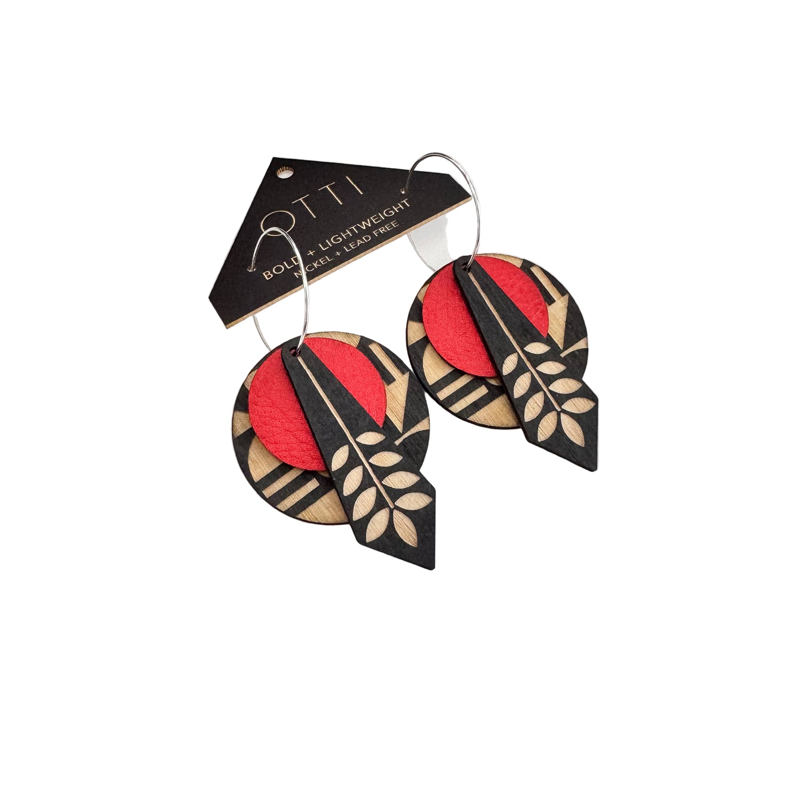 Pair of earrings with red, black, and beige design on a white surface with a brand card.