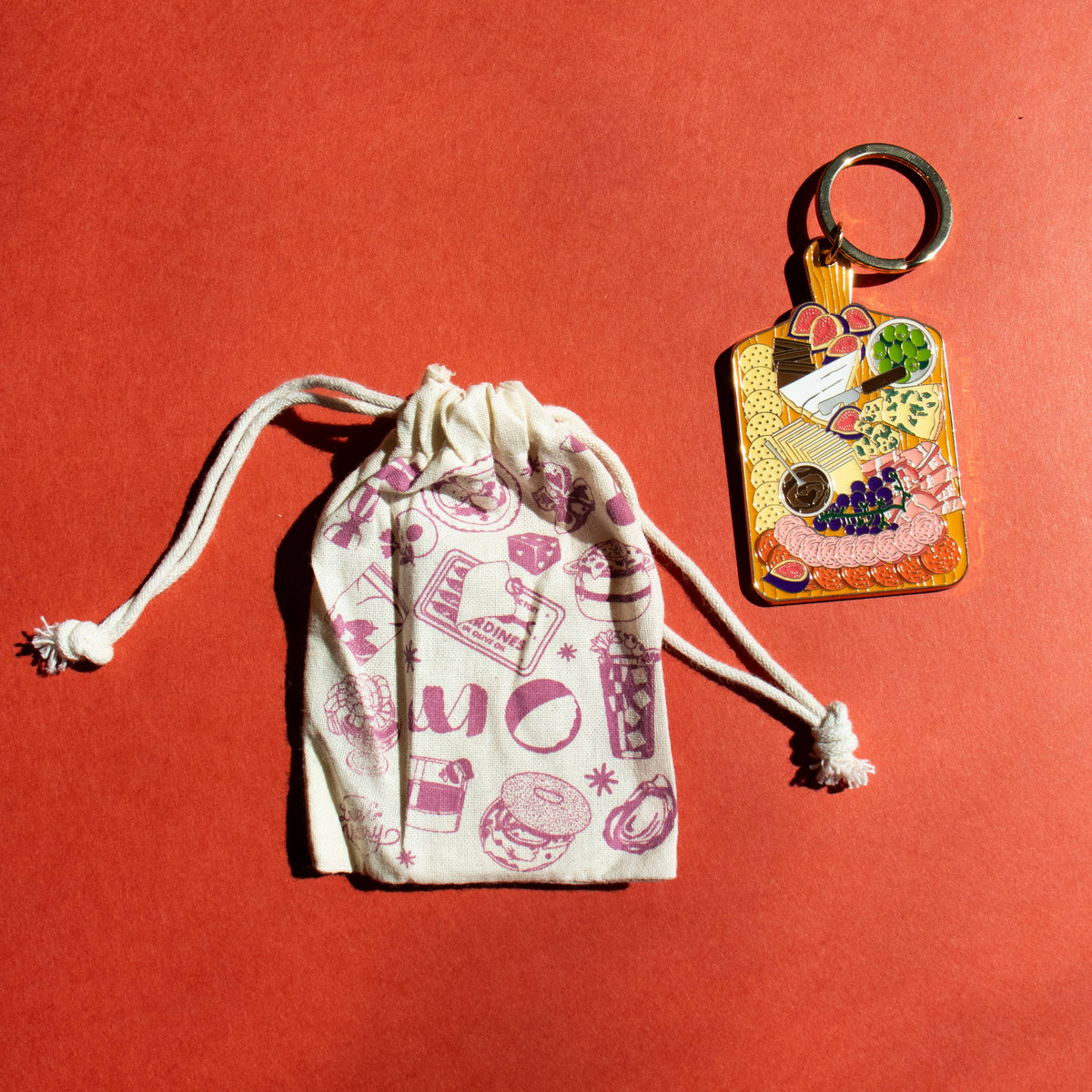 Drawstring bag with food-themed illustrations and a decorative keychain 