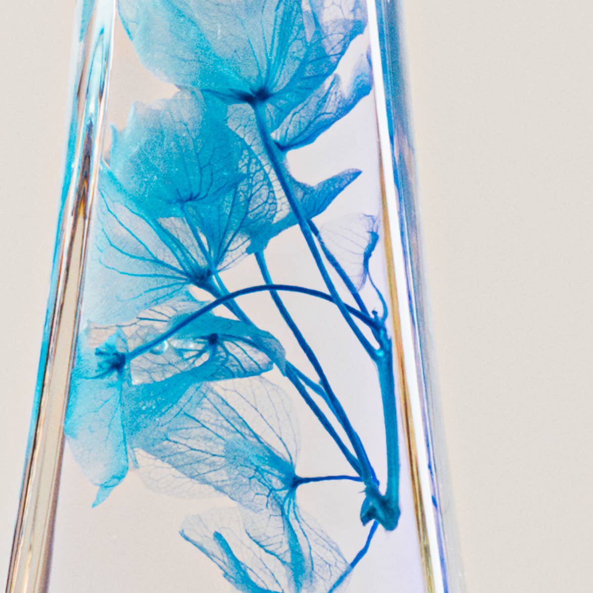 Clear glass vase with blue floral design on a light gray background