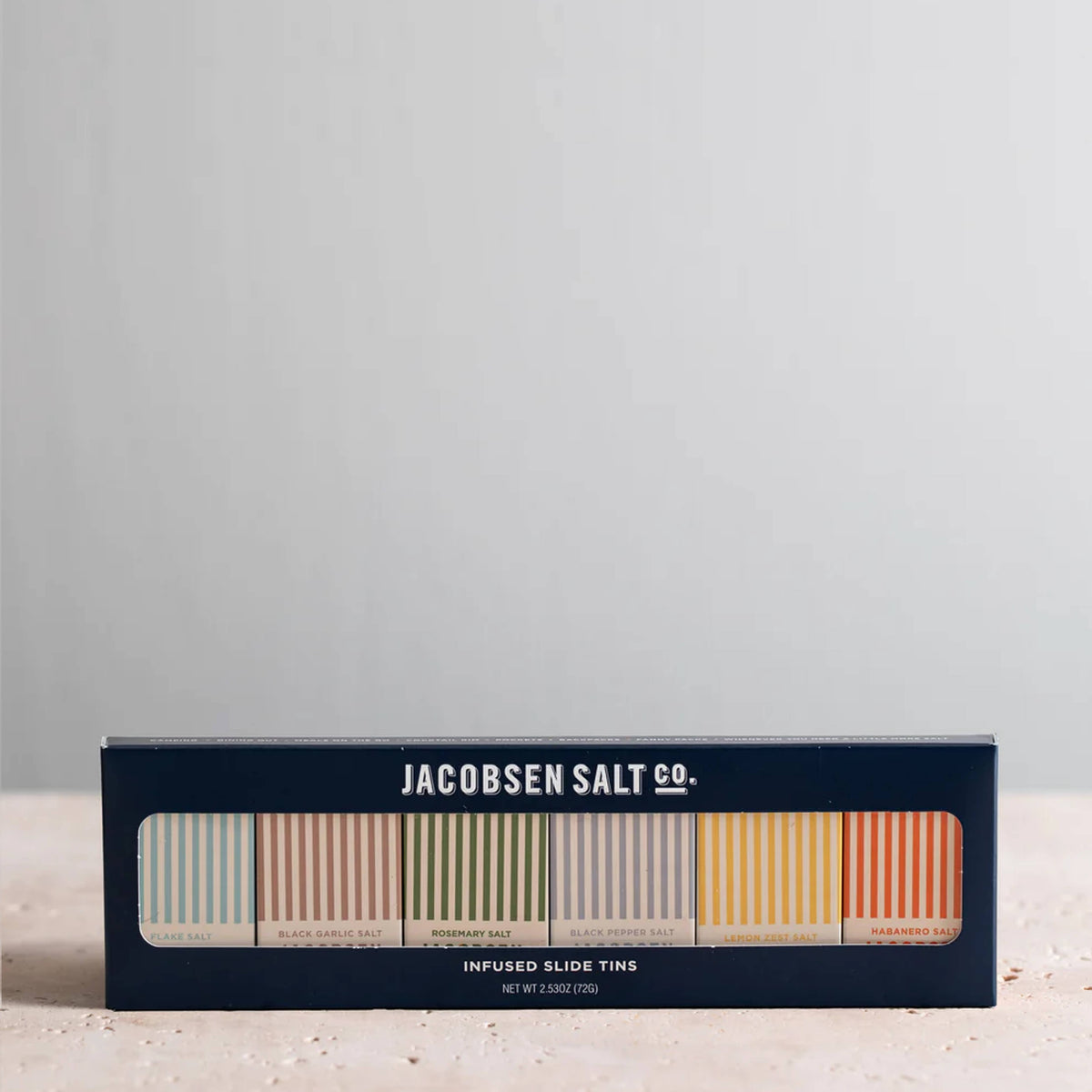Box of Jacobsen Salt Co. salt tins on a light gray background
