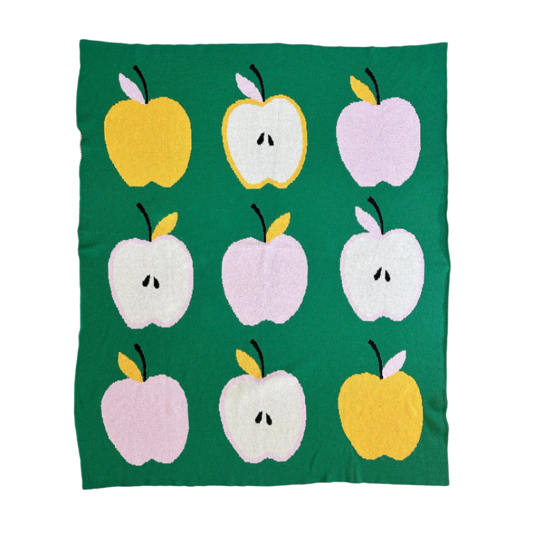 Blanket with colorful apple pattern on a green background
