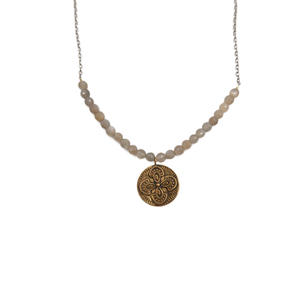 Necklace with moonstone beads and a bronze circular pendant on a white background