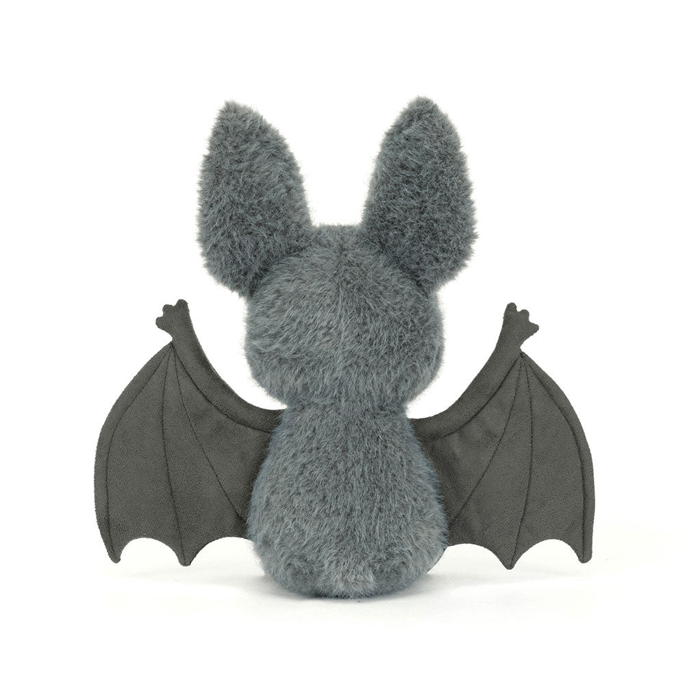 Back of Plush toy bat with gray fur and black wings on a white background