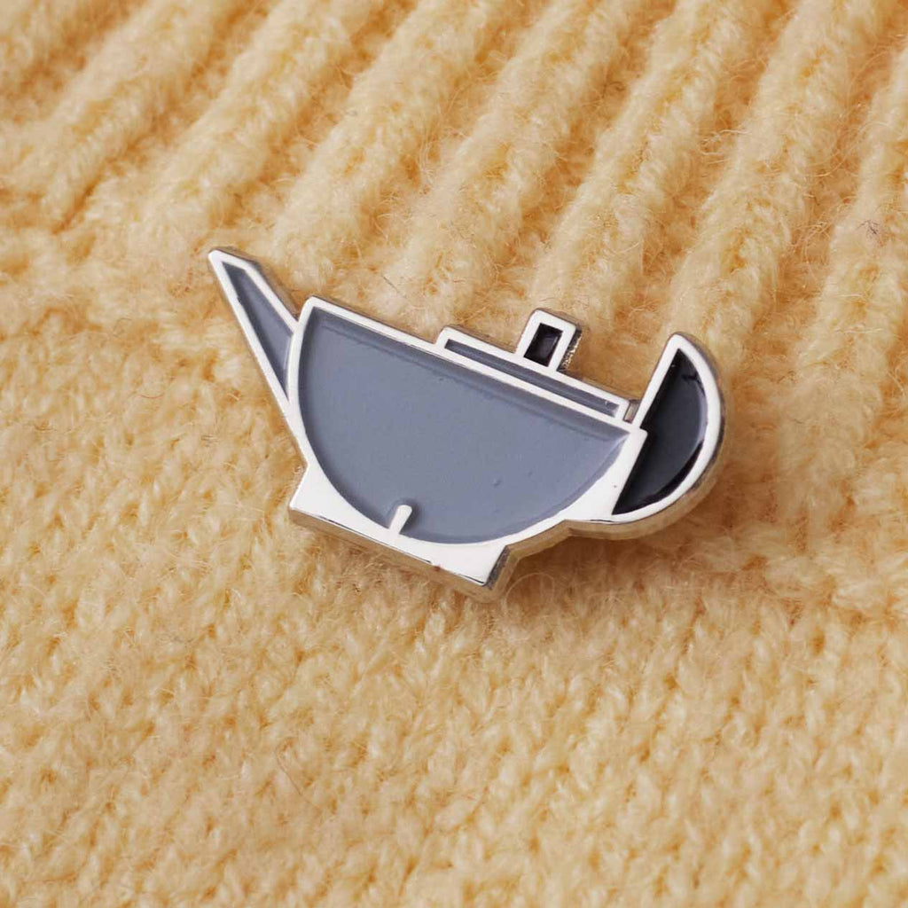 tea pot shaped pin on a cream sweater