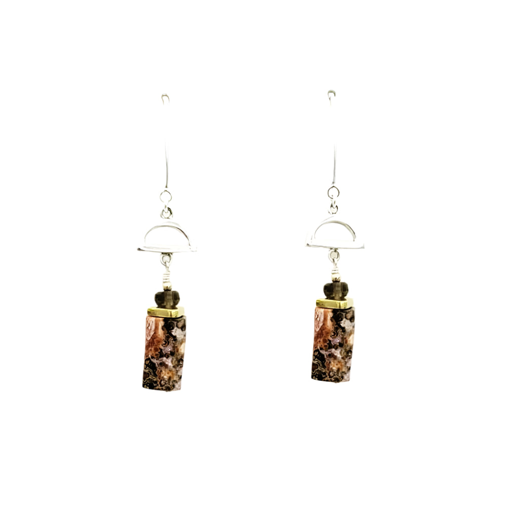 Pair of earrings with cylindrical gemstones on a white background
