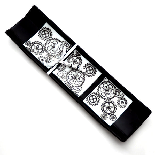 Black rectangular mat with white gear pattern on a white background