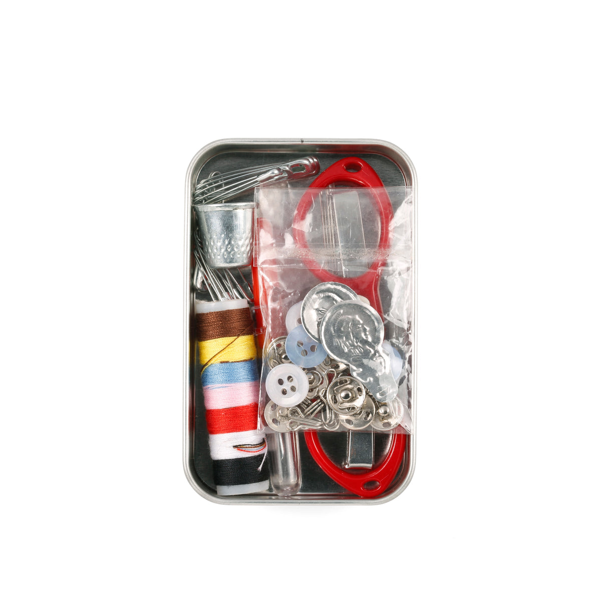 Sewing kit with various tools and materials in a metal tin on a white background
