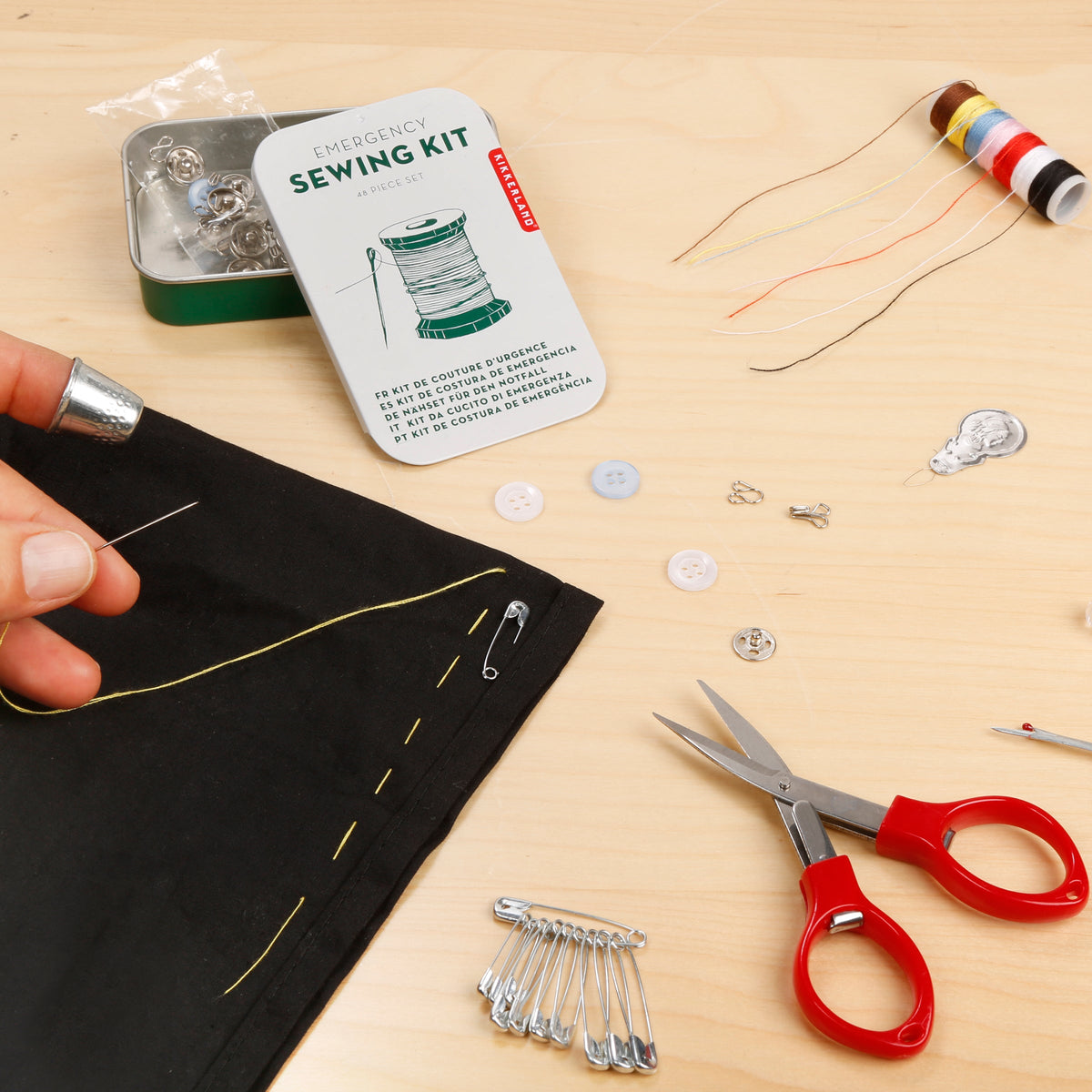 Sewing kit with scissors, thread, and fabric on a wooden surface