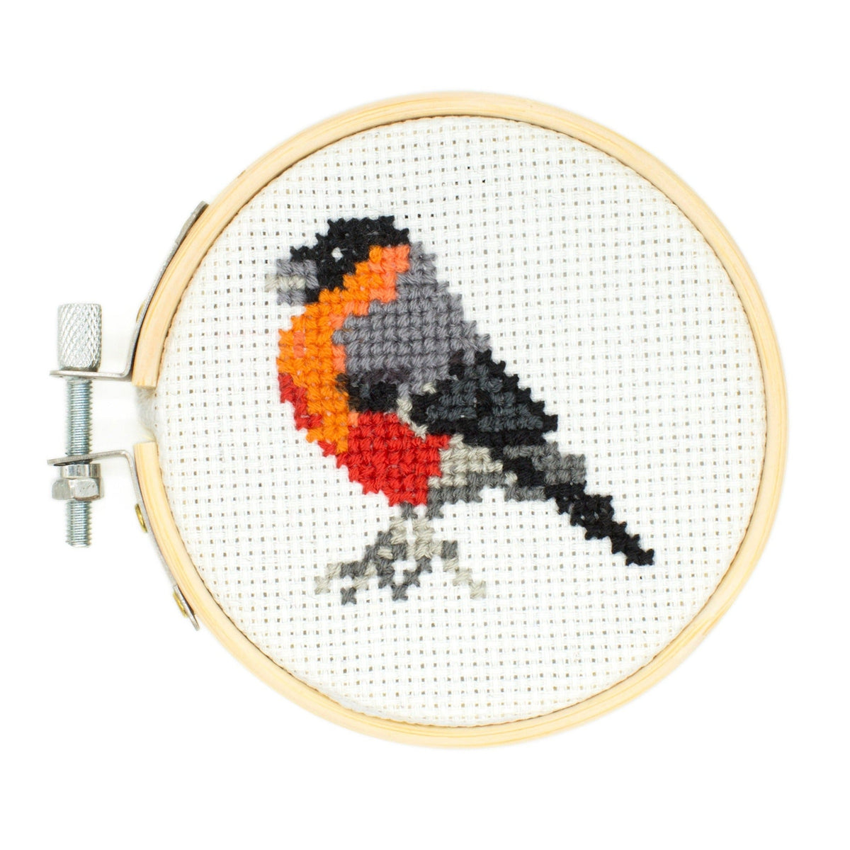 Cross-stitched bird design in a wooden hoop on a white background