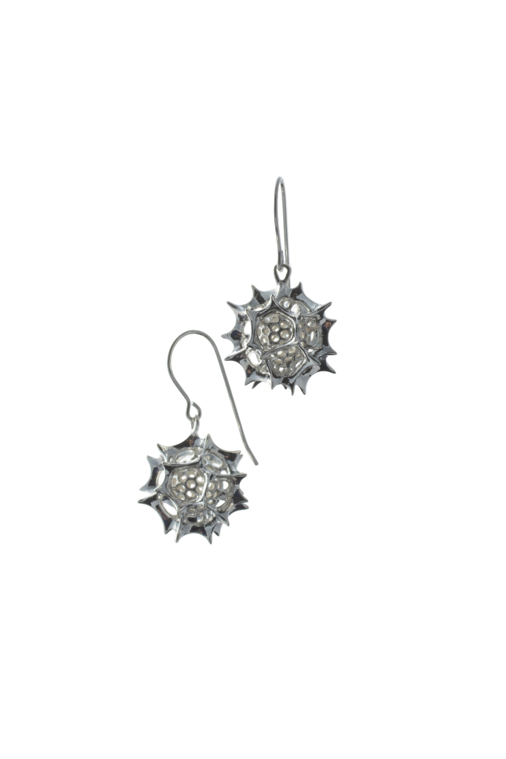 Pair of silver earrings with star-like design on a white background