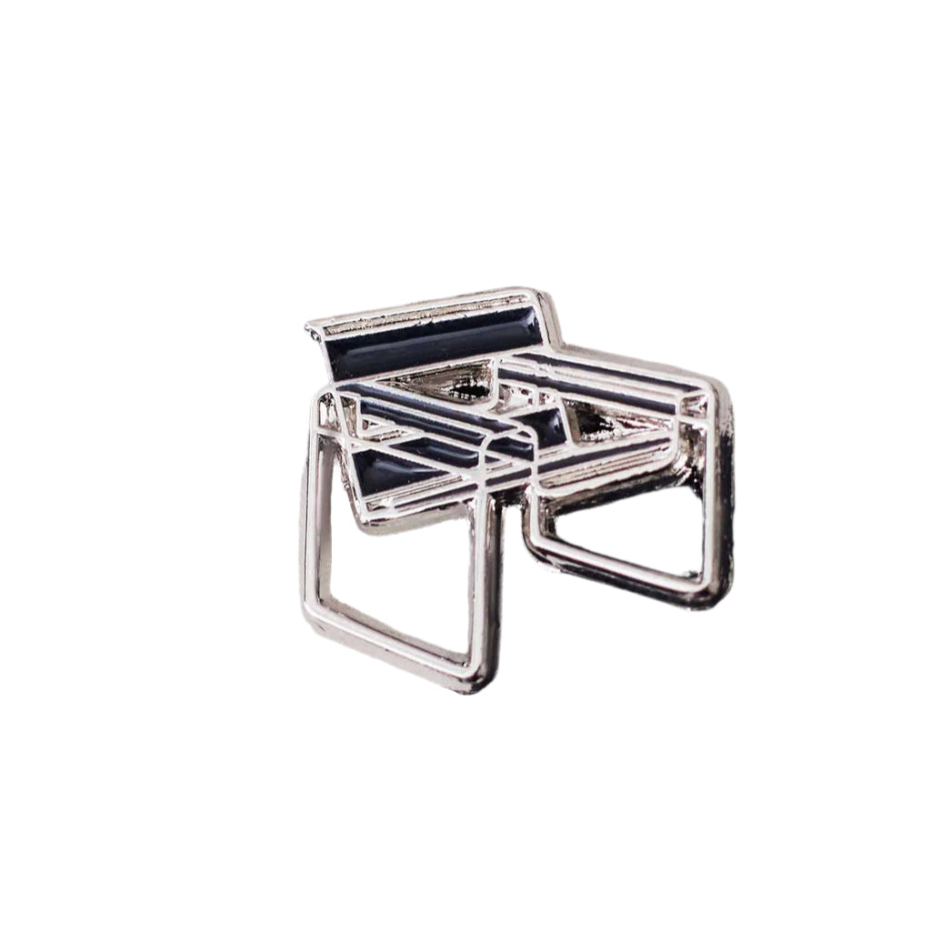 art deco silver and black chair pin on a white background