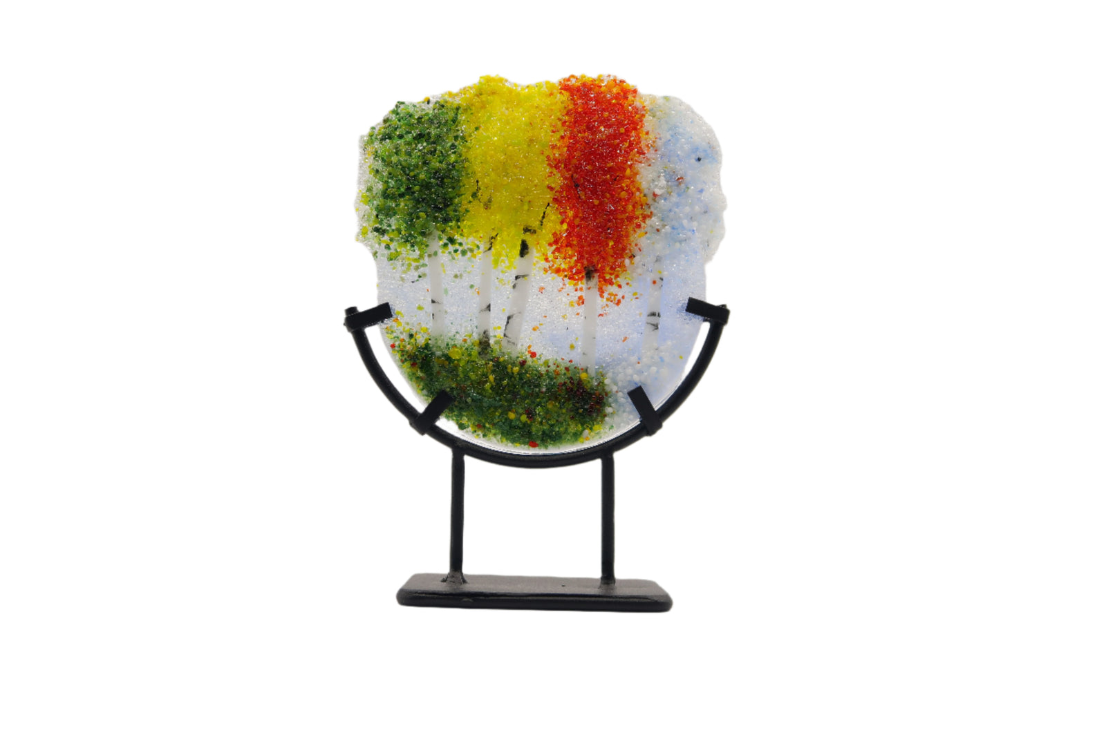 Decorative glass piece with green, yellow, red, white trees on a stand 