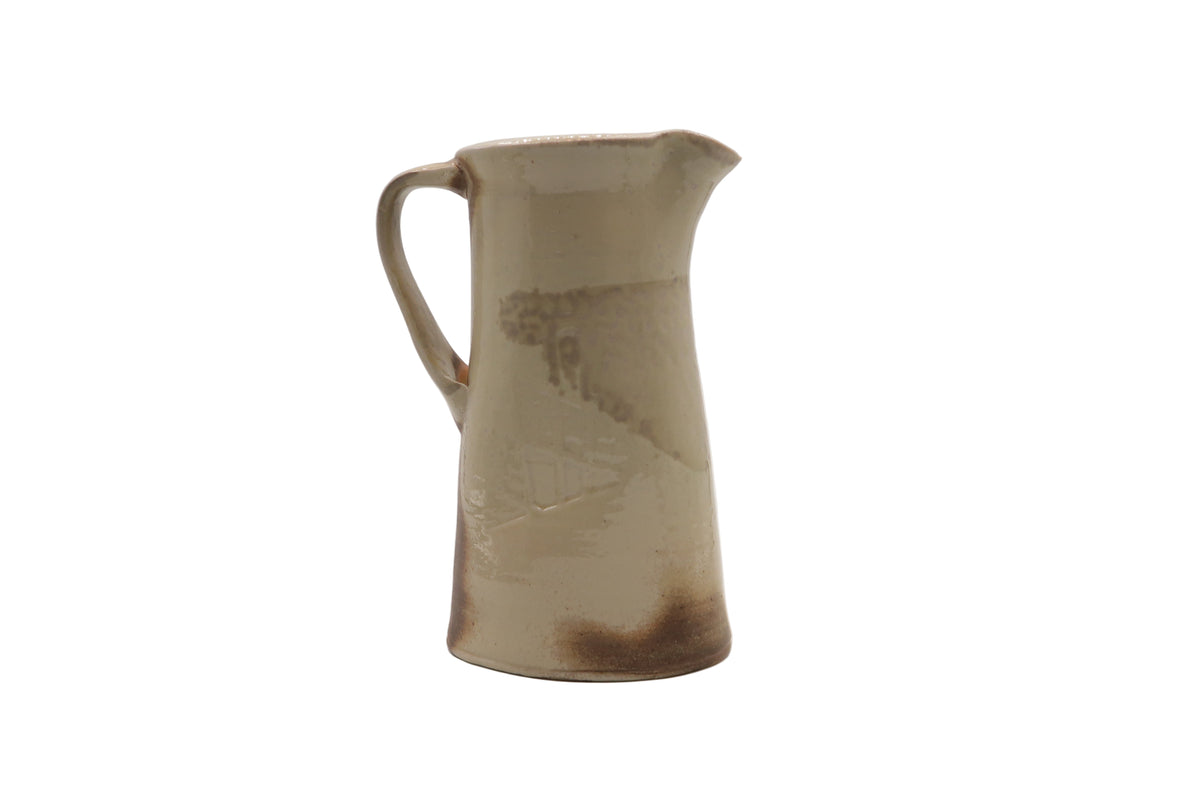 Ceramic pitcher with a brown glaze on a white background