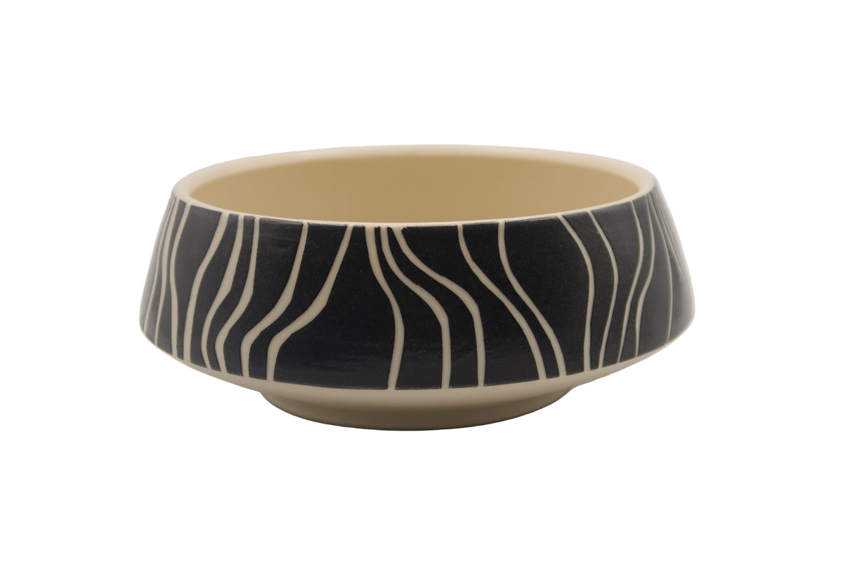 Ceramic bowl with black and white striped pattern on a white background