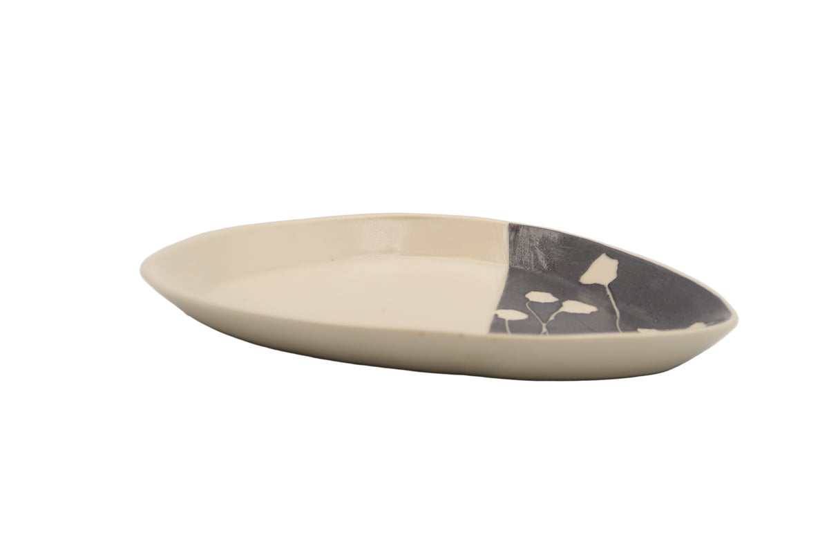 Ceramic plate with black and white design on a light gray background