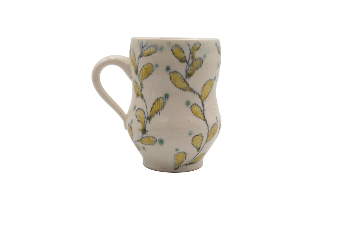 Ceramic mug with yellow floral pattern on a white background