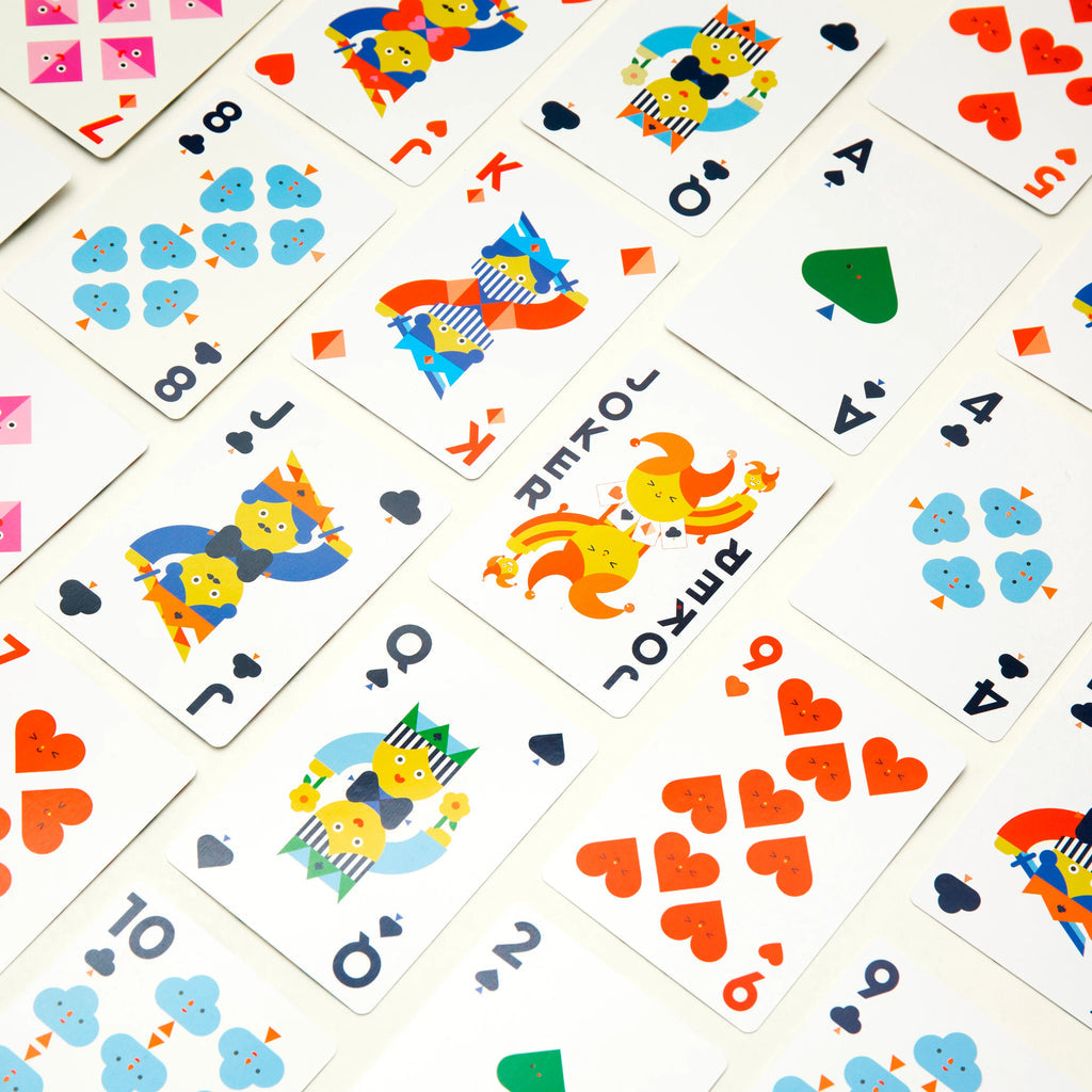 Colorful playing cards with cartoon characters and symbols on a white background