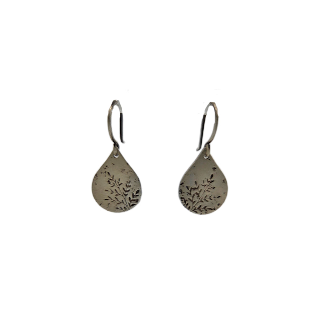 Pair of silver teardrop earrings with engraved designs on a white background